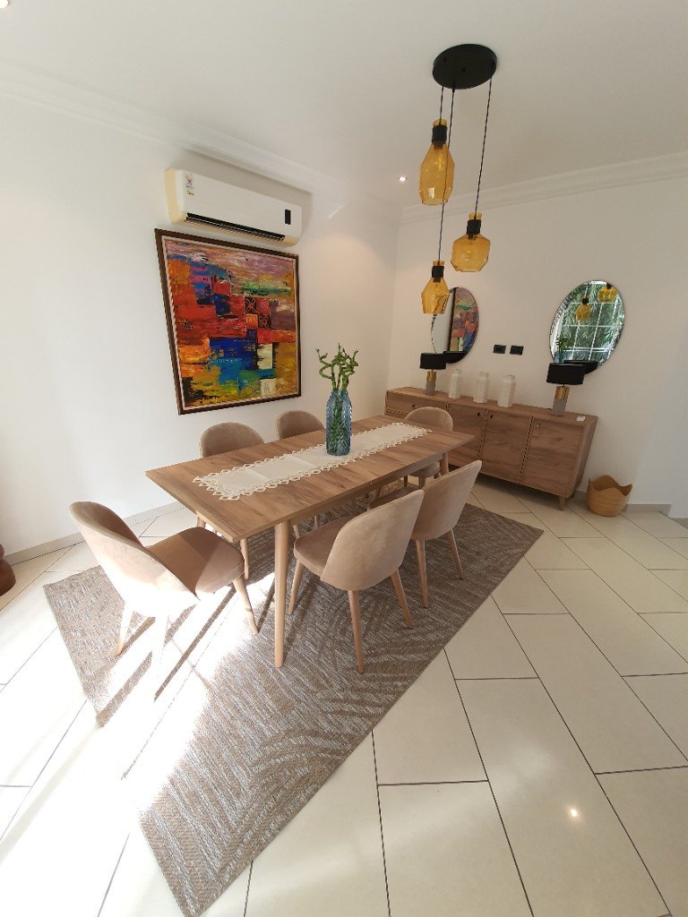 Contemporary dining room with light wood table and colorful artwork